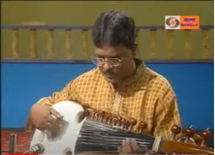 A man playing an instrument on the television.