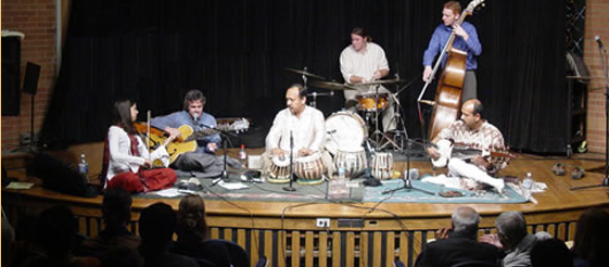 A group of people playing musical instruments on stage.