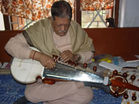 A man playing an instrument on the floor.
