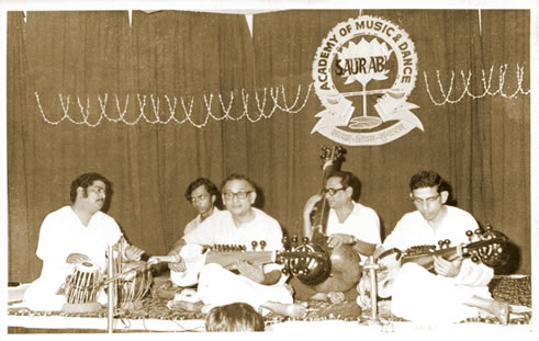 A group of people sitting on the ground playing instruments.