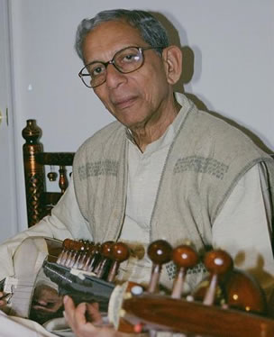 A man sitting in front of many musical instruments.