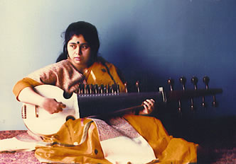 A woman sitting on the floor playing an instrument.